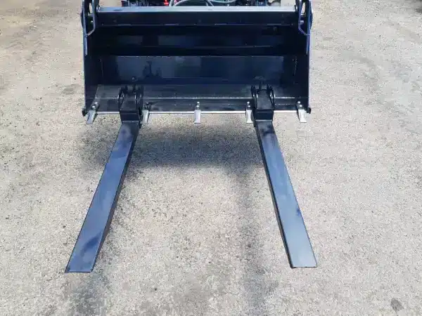 AgKing clamp-on pallet forks attached to a tractor's front loader